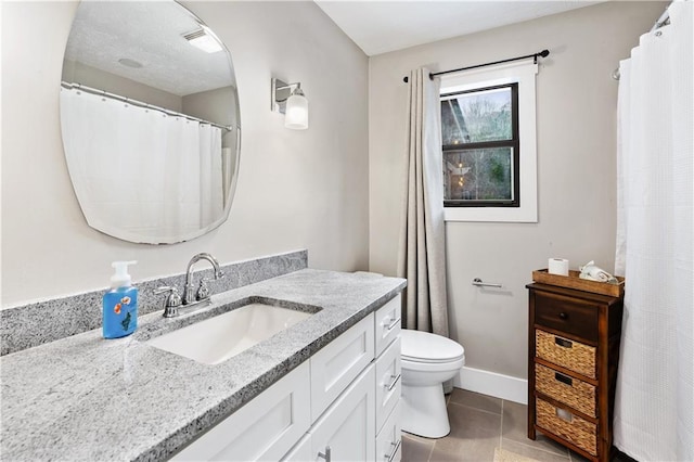 bathroom with toilet, vanity, and tile patterned floors