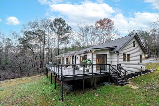 rear view of house featuring a yard and a deck