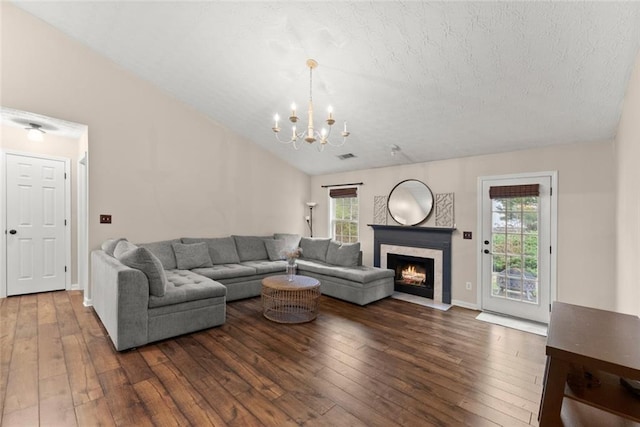 living room with plenty of natural light, wood-type flooring, a fireplace, and vaulted ceiling