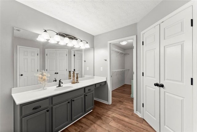 bathroom featuring visible vents, wood finished floors, a textured ceiling, vanity, and a closet