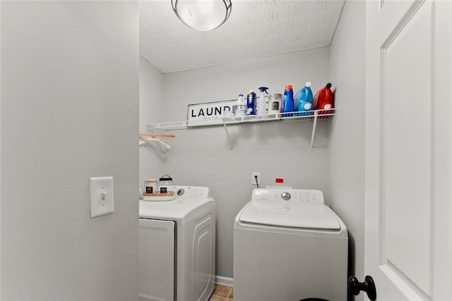 laundry area featuring a textured ceiling, laundry area, and washer and clothes dryer