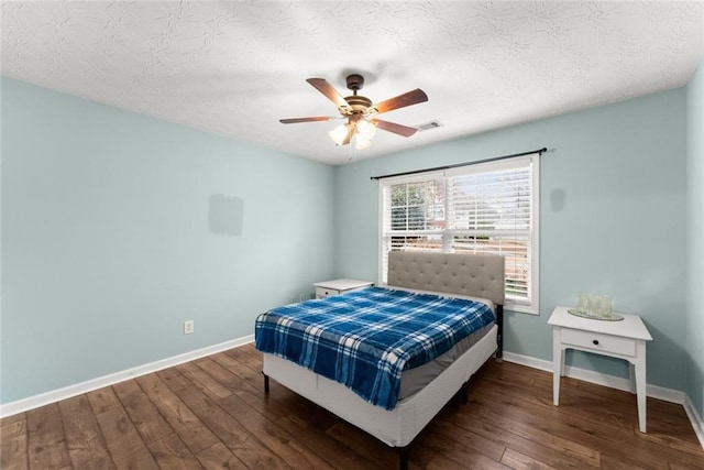 bedroom featuring baseboards, visible vents, hardwood / wood-style floors, and a textured ceiling