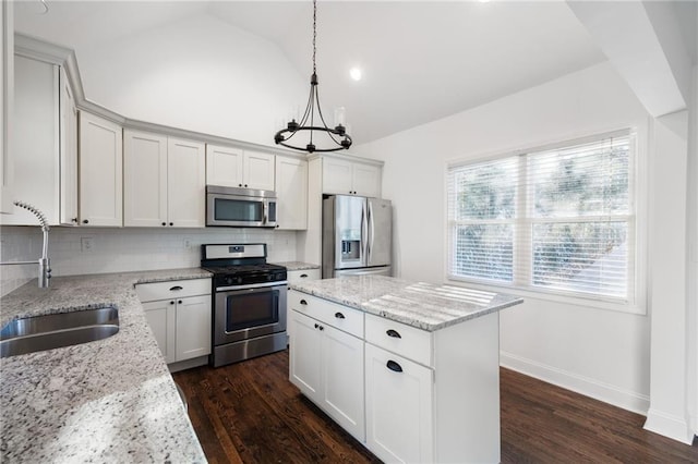 kitchen featuring vaulted ceiling, decorative backsplash, stainless steel appliances, and a sink