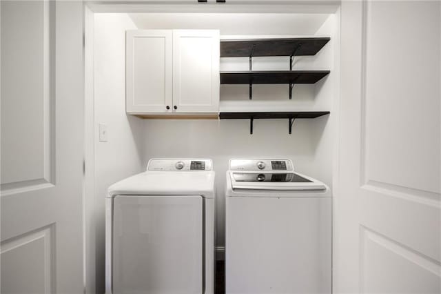 clothes washing area with cabinet space and washer and clothes dryer