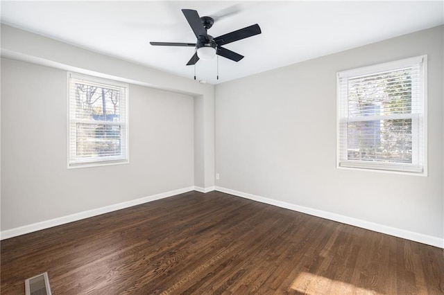 empty room with visible vents, a wealth of natural light, and baseboards