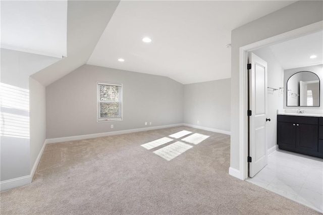 bonus room with light carpet, baseboards, a sink, and lofted ceiling