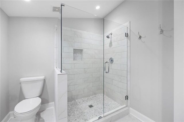 bathroom with marble finish floor, a shower stall, toilet, and baseboards