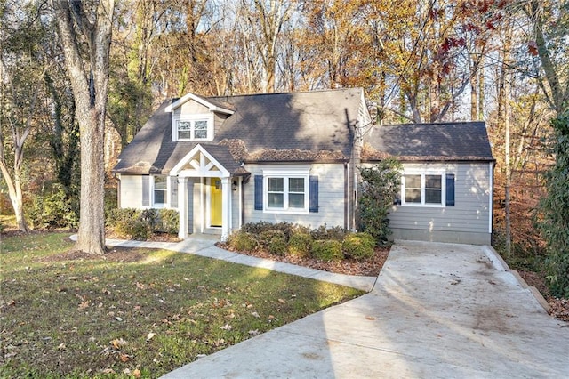 cape cod house featuring a front yard