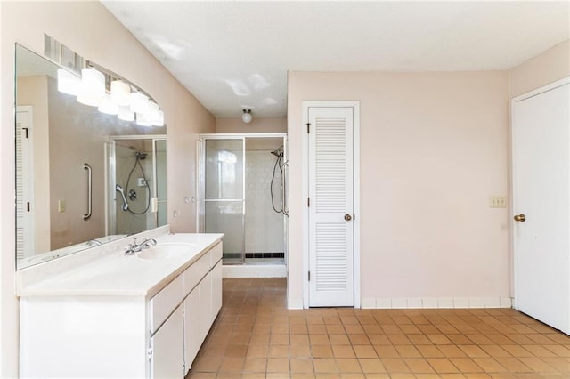 bathroom featuring tile patterned flooring, a closet, a shower stall, and vanity