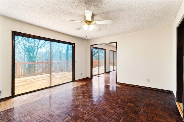 empty room featuring ceiling fan, a textured ceiling, and baseboards