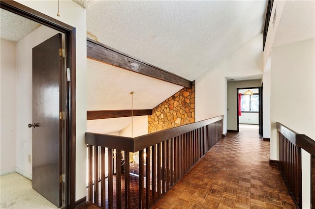 corridor with high vaulted ceiling, beamed ceiling, a textured ceiling, and baseboards