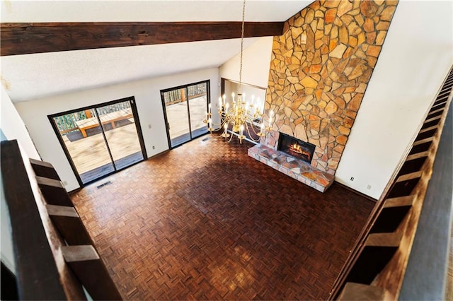 living area with visible vents, beamed ceiling, an inviting chandelier, a stone fireplace, and high vaulted ceiling