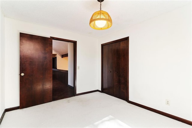 unfurnished bedroom featuring carpet, baseboards, and a closet