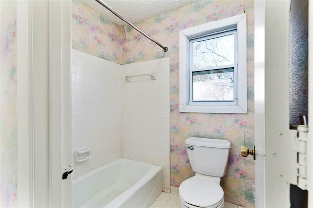 full bathroom with wallpapered walls, baseboards, toilet, tub / shower combination, and a textured ceiling