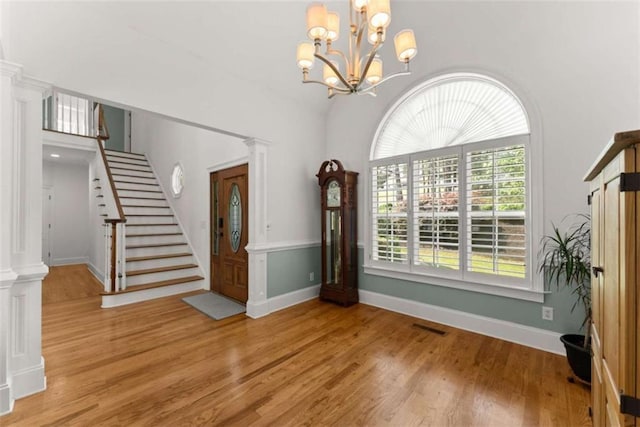 4514 Walking Stick Ln, Gainesville, GA 30506 - entrance foyer with light wood finished floors, a chandelier, stairway, ornate columns, and baseboards
