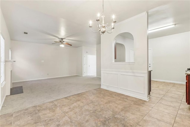 carpeted empty room featuring ceiling fan with notable chandelier and crown molding