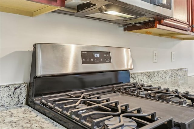 room details with stainless steel gas range and light stone countertops