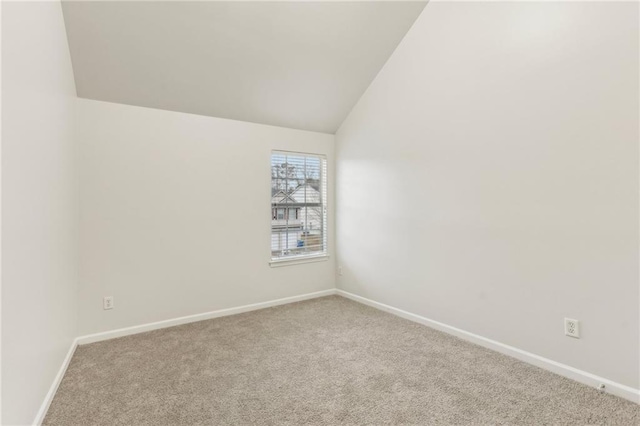 carpeted empty room with lofted ceiling