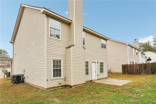 rear view of property featuring central air condition unit, a patio, and a lawn