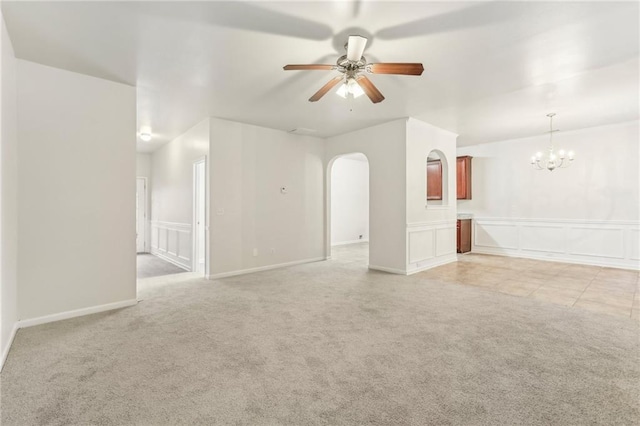 unfurnished room featuring ceiling fan with notable chandelier