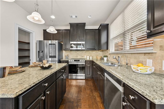 2396 Whiteoak Bnd SE Unit 16, Smyrna, GA 30080 - kitchen featuring appliances with stainless steel finishes, a sink, a center island, dark wood-style floors, and light stone countertops