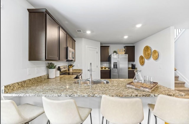 734 Great Oak Pl, Villa Rica, GA 30180 - kitchen with visible vents, a sink, appliances with stainless steel finishes, a peninsula, and dark brown cabinetry
