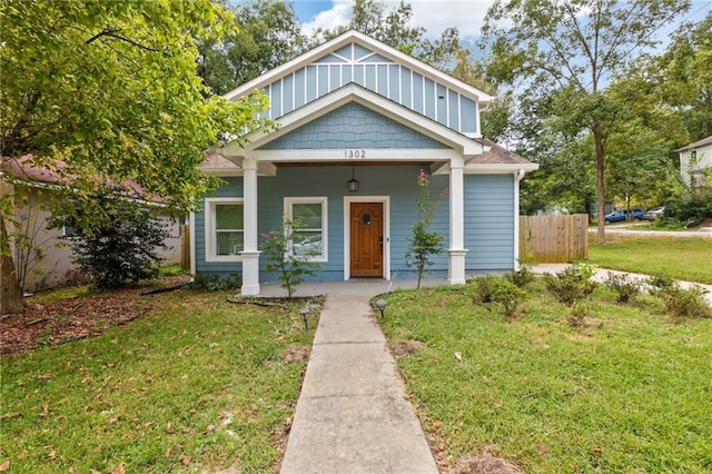 view of front of home with covered porch and a front lawn