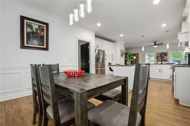 dining room featuring ceiling fan with notable chandelier, light hardwood / wood-style flooring, and ornamental molding