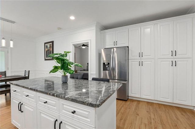 kitchen with a kitchen island, decorative light fixtures, white cabinetry, light hardwood / wood-style floors, and stainless steel fridge