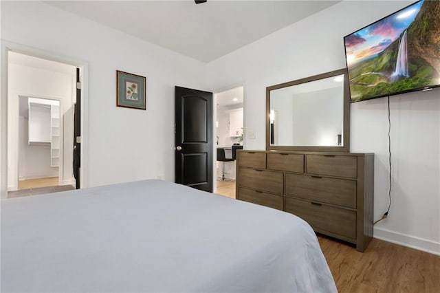 bedroom with light wood-type flooring and connected bathroom