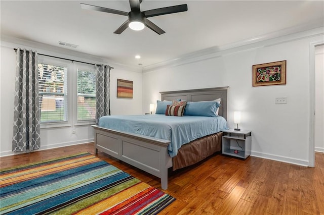 bedroom featuring dark hardwood / wood-style floors, ceiling fan, and ornamental molding