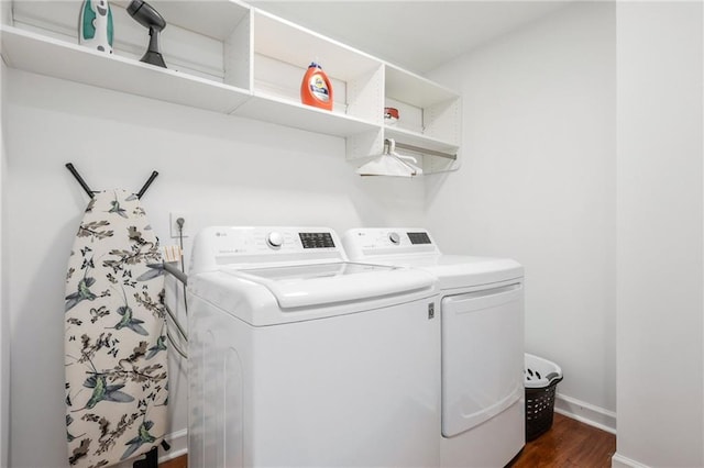 laundry area with washing machine and clothes dryer and dark hardwood / wood-style flooring