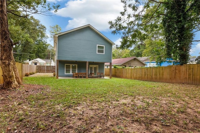 rear view of house featuring a patio area and a yard