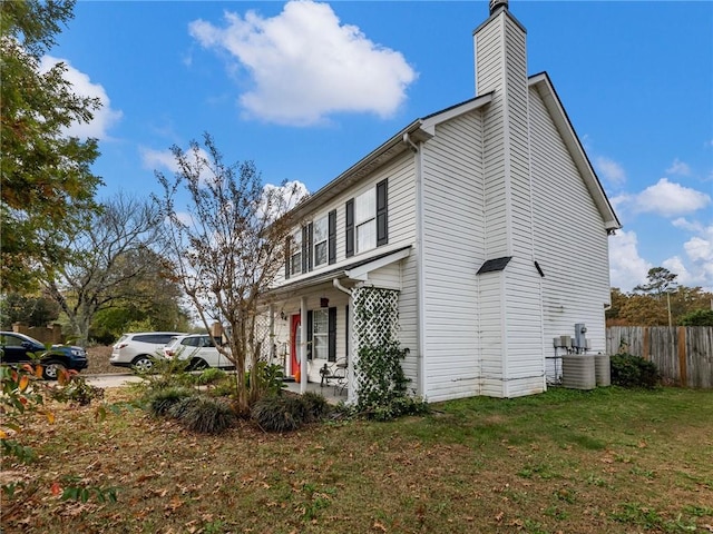 view of property exterior with a yard and central air condition unit