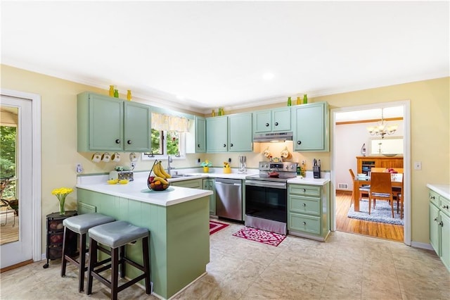 599 Palmer Ct SE, Conyers, GA 30094 - kitchen with crown molding, stainless steel appliances, an inviting chandelier, light tile floors, and a kitchen bar
