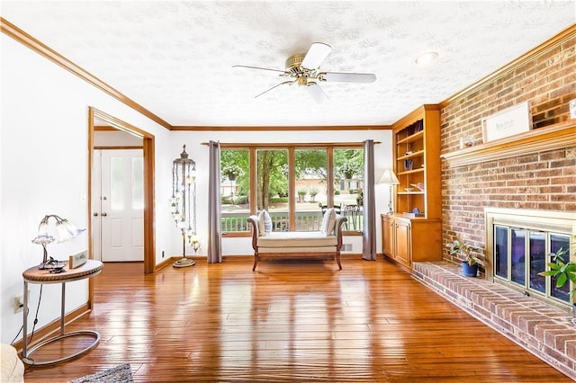 599 Palmer Ct SE, Conyers, GA 30094 - interior space with a fireplace, ceiling fan, crown molding, wood-type flooring, and a textured ceiling