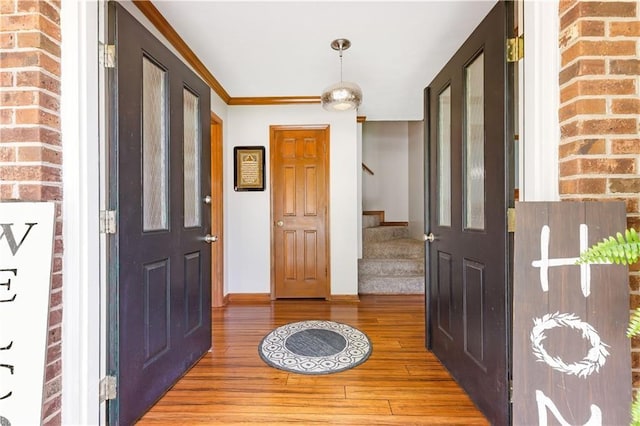 599 Palmer Ct SE, Conyers, GA 30094 - foyer entrance with brick wall, wood-type flooring, and crown molding