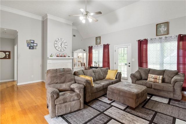 living area featuring light wood-style flooring, a ceiling fan, crown molding, baseboards, and vaulted ceiling