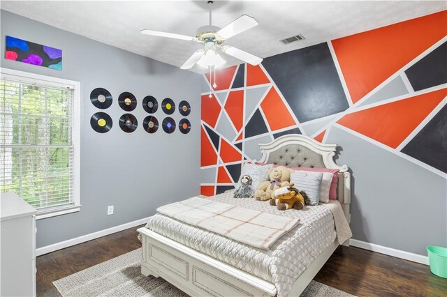 bedroom featuring baseboards, multiple windows, and wood finished floors