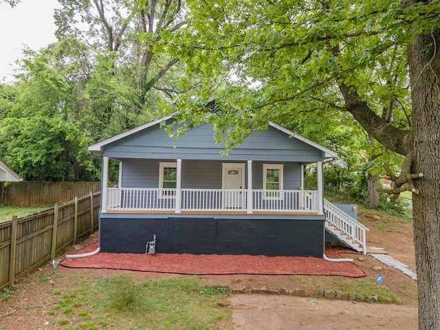 bungalow-style house with stairs, covered porch, and fence