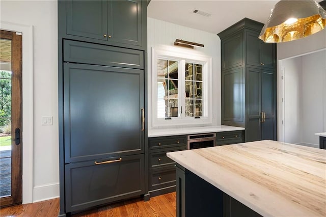 1830 Maple St, Carrollton, GA 30117 - kitchen with wood finished floors, light stone counters, oven, and baseboards