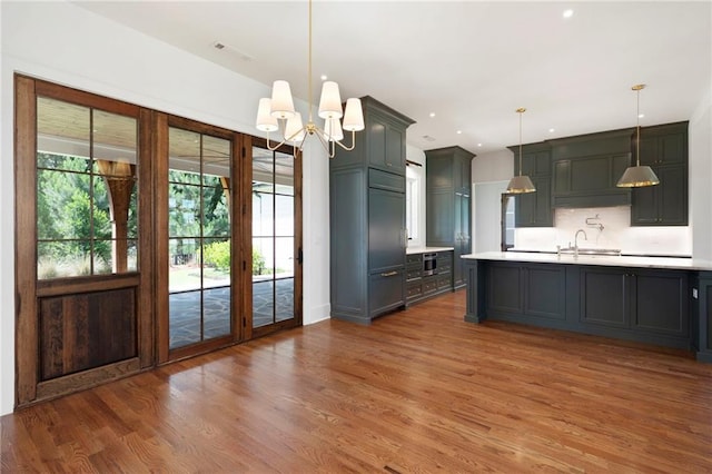 1830 Maple St, Carrollton, GA 30117 - kitchen featuring light countertops, a sink, wood finished floors, backsplash, and recessed lighting