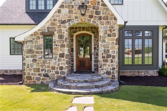 1830 Maple St, Carrollton, GA 30117 - property entrance featuring stone siding, board and batten siding, a shingled roof, and a lawn