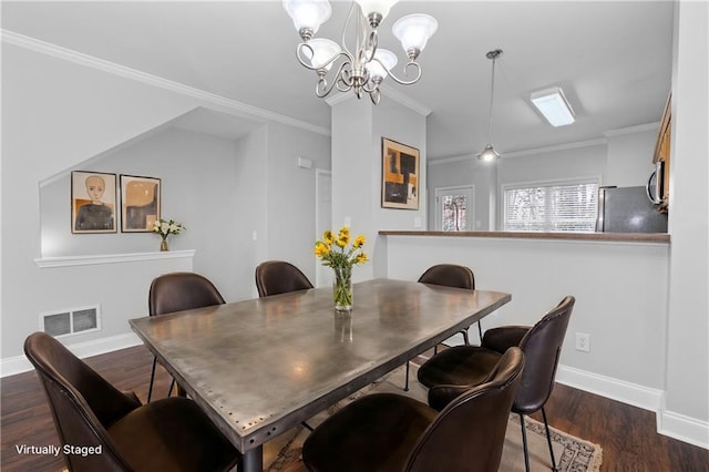 dining space featuring a notable chandelier, ornamental molding, and dark hardwood / wood-style floors