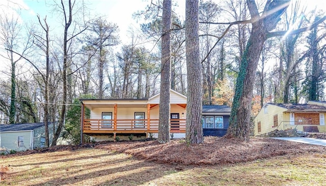 view of front facade with a front yard, covered porch, and a storage shed