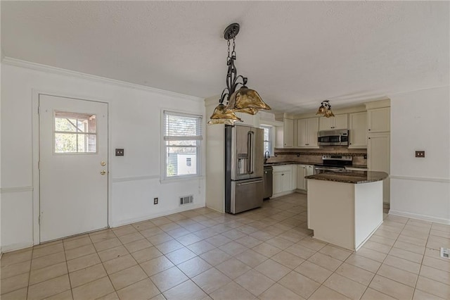 kitchen featuring crown molding, appliances with stainless steel finishes, hanging light fixtures, and light tile patterned floors