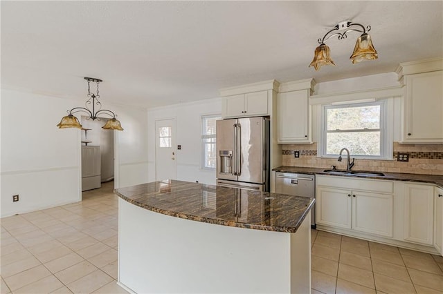 kitchen featuring sink, appliances with stainless steel finishes, a kitchen island, pendant lighting, and backsplash