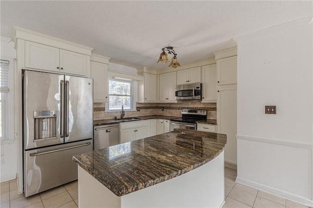 kitchen featuring sink, backsplash, a kitchen island, stainless steel appliances, and light tile patterned flooring