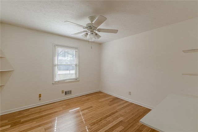 unfurnished room featuring ceiling fan, a textured ceiling, and light wood-type flooring