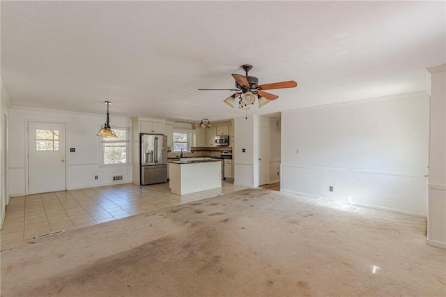 unfurnished living room with light carpet, sink, crown molding, and ceiling fan